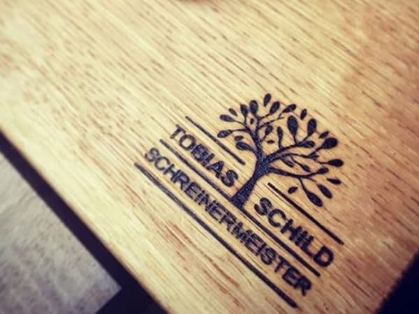 Das Bild zeigt einen per Brennstempel erzeugten Abdruck auf Holz.