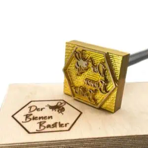 Brennplatte mit Bienenwabenmotiv und einem Holzbrett mit Brennzeichen.