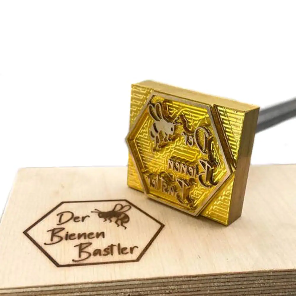 Brennplatte mit Bienenwabenmotiv und einem Holzbrett mit Brennzeichen.