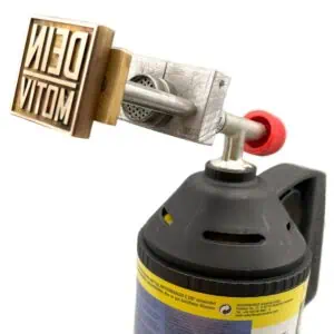 Ein Adapter zum Einspannen der Platte am Gasbrenner mit Aufsatz und zwei Stegen die fest mit der Platte verbunden sind. Diese Stege gehen durch zwei Löcher am Aufsatz die mit Muttern befestigt werden.