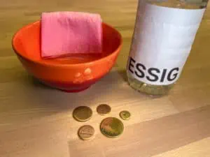 Das Foto zeigt eine rote Schüssel mit Essig und verdeutlicht das Thema "Messing und Messingtoken reinigen".