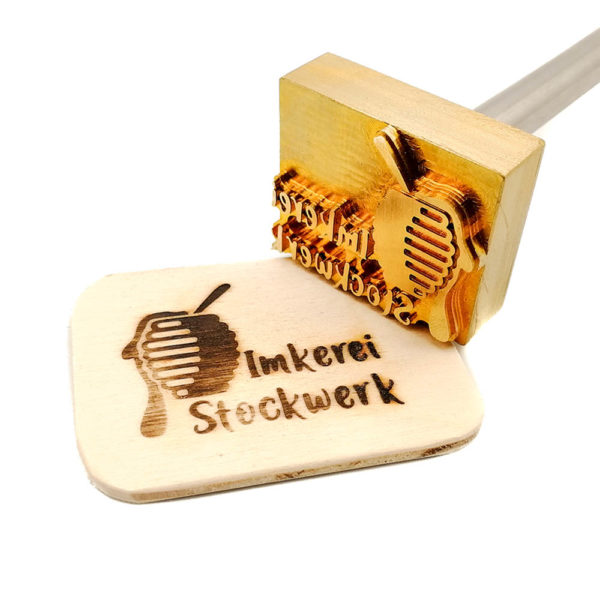 Fotografiert wurde ein Motiv, dass ideal für einen Imker ist. Links oben befindet sich ein stilisierter Bienenstock mit vielen Wölbungen, die abgerundeten Wellen werden dabei sowohl nach oben als auch nach unten kleiner es entsteht dabei der Eindruck einer Ellipse. In dem Bienenstock steckt ein Löffel von dem der Griff herausragt. Der Bienenstock ist über und über mit Honig gefüllt. Er quillt über und läuft auf der linken Seite heraus. Rechts davon befindet sich der Schriftzug mit dem Inhalt „Imkerei Stockwerk“ in einer verspielten Schriftart. Sowohl Typografie als auch der Text sind individuell anpassbar.