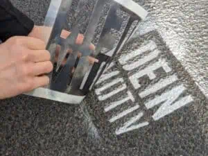 Das Foto zeigt ein Motiv, das mittels Sprühschablone auf Asphalt aufgetragen wurde.