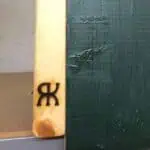 Das Bild zeigt ein auf Holz aufgebrachtes Brandzeichen.