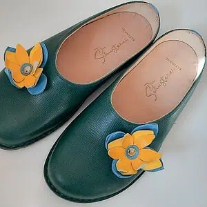 Das Bild zeigt grüne Lederschuhe mit Branding.