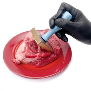 Rindfleisch wird von einer Hand mit schwarzen Handschuhen bedruckt mit einem Fleischbeschaustempel/ Schlachthofstempel/ Tauglichkeitskennzeichnung/Genusstauglichkeitskennzeichnung