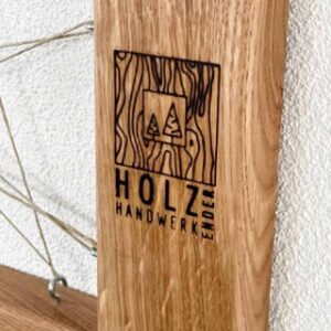 Das Kundenfoto zeigt ein Brandzeichenmotiv auf massivem Holzrahmen.