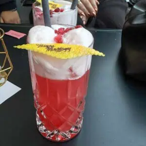 Auf dem Foto ist ein Getränk mit verzierter Zitronenschale zu sehen.