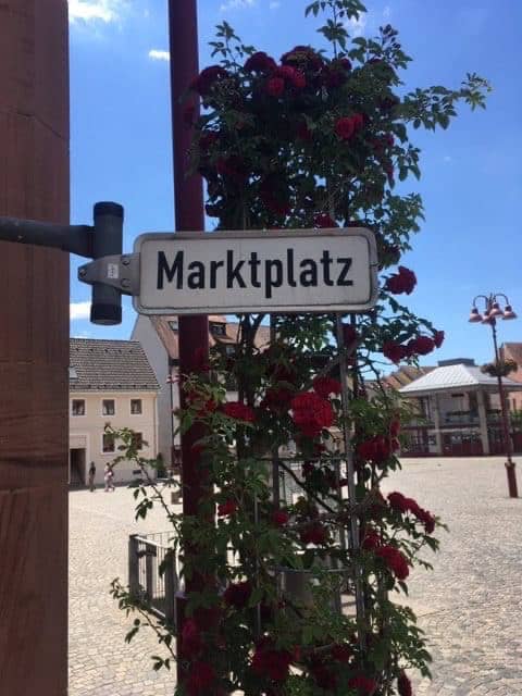 Das Foto zeigt einen Marktplatz mit Beschilderung.