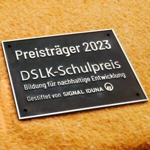 Das Bild ein patiniertes Messingschild für eine Schule.