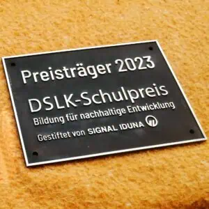 Das Bild ein patiniertes Messingschild für eine Schule.