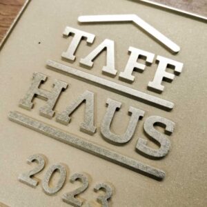 Das Foto zeigt ein Firmenschild aus Messing.