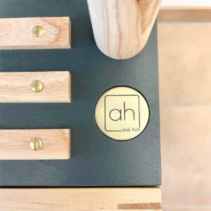 Das Bild zeigt ein im Holzmöbel eingearbeitetes Messing-Token.